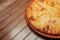 Top view on tasty traditional megrelian khachapuri - pie with melted salt cheese suluguni and egg yolk on wooden tray. Traditional