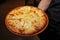 Top view on tasty traditional megrelian khachapuri - pie with melted salt cheese suluguni and egg yolk on wooden tray. Traditional