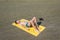 Top view on the teen boy lying on yellow towel and sunbathes on the beach. Concept.teen,boy,one,swimming.
