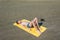 Top view on the teen boy lying on yellow towel and sunbathes on the beach. Concept.teen,boy,one,swimming.