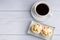 Top view of Thai steamed cupcakes topped with dry fruit on a plate on a blue cloth with a white coffee cup. Khanom Pui Fai