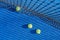top view of three balls on a blue paddle tennis court, racket sports