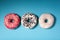 Top view of three donuts isolated on blue background