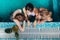 Top view of three female swimmers sitting in a swimming pool resting after training and gossiping