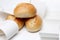 Top view of three german wheat buns in a bunch of empty receipts on white isolated background, receipt obligation in germany also