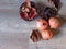 Top view of three pomegranate fruit, dried leaves and organic dried peeled skin in a basket on oak wood table background.