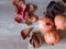 Top view of three pomegranate fruit, dried leaves and organic dried peeled skin on oak wood table background. Punica granatum.