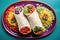 top view of three types of burritos on a colorful platter