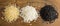 Top view of three varieties of rice on wood background