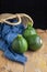 Top view of three zucchini with blue checkered cloth and basket, on wooden table and black background