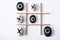 Top view of tic tac toe game with grid made of paper tubes, and pebbles marked with naughts and crosses