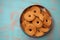 Top view of tin box with butter cookies/biscuits on wooden teal green rustic background with space for text