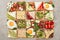 Top view of toasts with fried eggs, cut vegetables and fruits on textured surface.