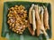 Top view of Tofu in peanut garlic sauce and Dynamite lumpia placed on a tray lined with banana leaves.