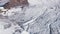 Top view of tourist walking in snowy mountains. Clip. Climber walks along snowy slopes of massive mountain on sunny day