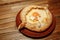 Top view on traditional Adjarian Khachapuri - open baked pie with melted salt cheese suluguni and egg yolk on wooden tray.
