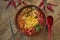 Top view on traditional Korean noodles soup with hot pepper, meat, shiitake mushrooms and omelet in a ceramic plate on a wooden