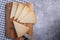 Top view of triangle pieces of cured Manchego cheese and a sharp knife on a wooden food board