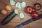 Top view of two chicken eggs, cucumber, red tomatoes on a branch, knife