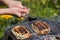 Top view on two grilled slices of homemade halloumi cheese on grill in woman`s hands.. Outdoors. Grilling season