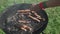 Top view of two men cooking grilling bacon and sausages on bbq grid