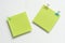 top view of two mini blank green notepad with colour paperclips on white background, copy space