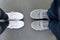 Top view of two pairs of sneakers shoes, legs of loving couple