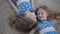 Top view of two pretty Caucasian twin sisters lying on soft carpet and smiling. Camera moving around faces of cute