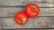 Top view. Two Spoiled Organic Ripe Red Tomatoes with Black Spots on Wood Texture Background. Tomato Diseases.