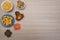 Top view of typical June Party foods on a wooden table: Popcorn, cornmeal cake, corn kernels, peanut pods, peanuts candies paÃ§