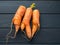 Top view of ugly vegetable with double carrots on black wooden background