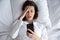 Top view unhappy woman using phone, bad news, oversleep