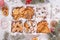 Top view of unpacked christmas present with sweets on a white textured surface framed by fir branches, close-up.