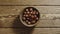 TOP VIEW: Unpeeled hazelnuts fill wooden cup on a wooden table