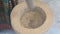 Top view of unrecognizable indian man grinding ingredients in a stone mortar and pestle for preparation of seasonings