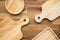 Top view of unused brand new brown handmade wooden kitchen utensil, dish plate and cutting board on wooden table background