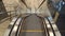 Top view of upward moving empty escalator with glass railings