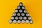 Top view of used batteries arranged in a triangle shape isolated on a yellow background