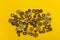 Top view on variety of different small gears laying on yellow background