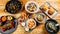 Top view of a variety of seafood, salads, and fried potatoes with sauces on trays on the table