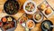 Top view of a variety of seafood, salads, and fried potatoes with sauces on trays on the table