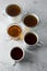 Top view of various cups, mugs with hot tea drink on light background, copy space. Tea time or tea brake. Autumn beverage. Toned