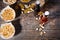 Top view of various snacks in plates like pistachios, small pretzels and peanuts near two beer bottles on dark wooden desk