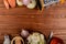 top view of vegetables as different types of whole cut and sliced onions potato with salt butter knife and grater on wooden