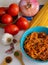 Top view vertical of spaghetti bolognese with its ingredients, tomato, onion, garlic and spices