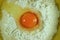 Top view of vibrant color egg yolk on the middle of white raw flour