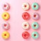 Top view of vibrant donuts colorful delights with sprinkles on pink