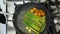 Top view video of preparing asparagus and small cherry tomatoes with butter in frying pan