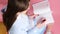 Top view video of a teenage school girl with manicure drawing heart sign in the notebook using blue pen.