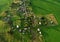 Top view of the village with wooden houses in wild among the forest and field. Aerial view of country house in countryside. Roofs